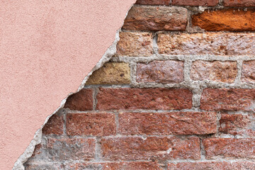 Brick wall with peeling pink plaster and exposed texture