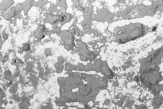 Rough gray textured concrete wall with peeling paint