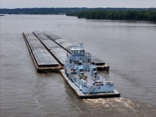 Rear view of a Tug boat pushing a large set of barges down  the Mississippi River