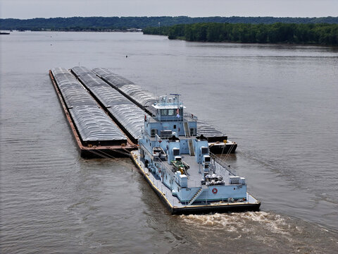 Rear view of a Tug boat pushing a large set of barges down  the Mississippi River