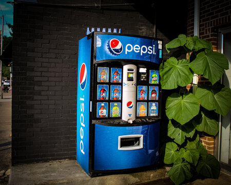 A Pepsi vending machine offering several types of bottled soda by a building wall in Bryson City, NC on July 5, 2025 (USA). For Editorial Use.