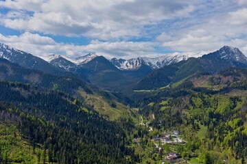 A scenic mountain landscape with snow-capped peaks and lush green valleys fills the frame in Zakopane - Lesser Poland - Poland