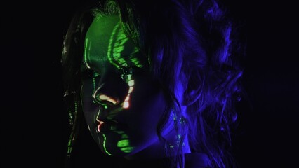 Portrait of a woman with green digital code projection on her face.