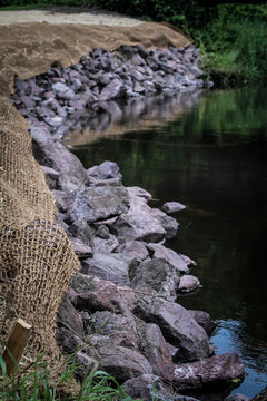 a stabilization project along a stream or creek waterway. watershed restoration with riprap and an erosion control blanket.