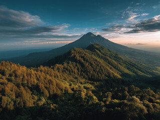 Obraz premium Majestic Mountain Peak Over Lush Forest at Sunrise