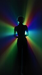 Silhouette of woman in rainbow light burst