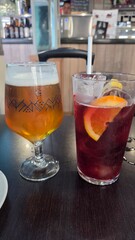 Refreshing summer drinks with fruit and ice in a cafe setting. Tinto de verano and beer. Summer cocktail and a glass of beer in Spanish bar