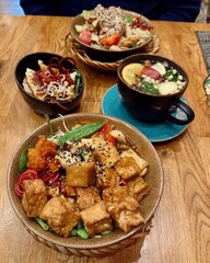 Gesunde vegane Bowls mit Tofu, Gemüse und Superfoods – serviert mit Heißgetränk
