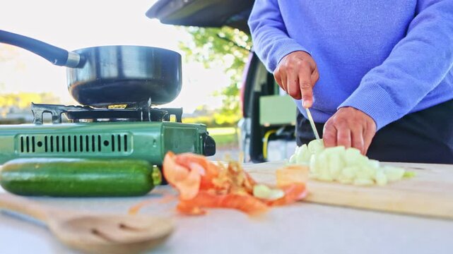 Woman cooking outside her van in autumn in New Zealand