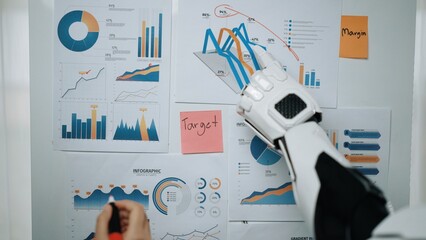 A robotic arm engages with various business reports displaying vibrant charts and graphs,...