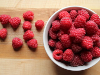 fresh raspberries in a bowl on wooden bacground