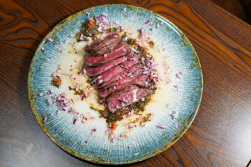 Sliced rare steak with sauce – top view