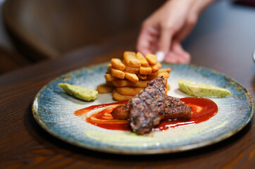 Grilled steak with fries and sauce – restaurant plate