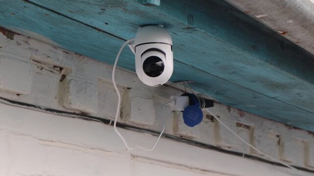 Security camera rotating and monitoring building exterior, capturing panoramic surveillance with advanced technological protection and detection capabilities