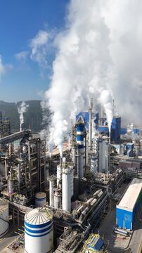 Vis&atilde;o a&eacute;rea vertical em 4K de uma ind&uacute;stria de papel e celulose com chamin&eacute;s e caldeiras, ilustrando o processo produtivo e o cen&aacute;rio industrial brasileiro
