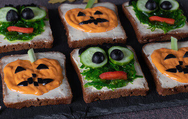 Sandwiches with green monsters and scary pumpkins for Halloween party, Closeup
