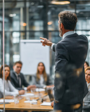 Lider zespołu intensywnie dyskutuje i podnosi głos na pracownik&oacute;w podczas spotkania w sali konferencyjnej. Emocje, napięcie i presja w środowisku pracy.

