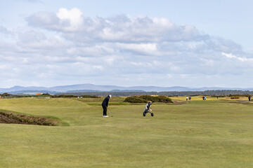 a golfer playing at the old course in st andrews in Scotland