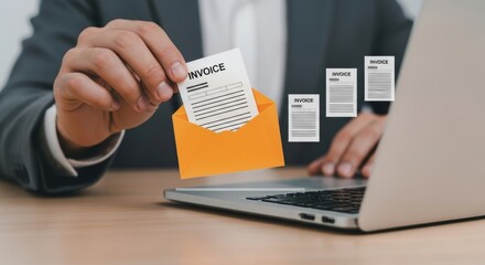 A hand pulls an invoice from an email on a laptop for business