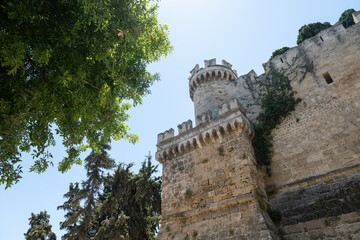 Set beneath the historic ramparts of Rhodes Castle, this photo captures a cylindrical turret...