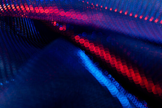 Abstract red and blue bokeh lights in wave formation on dark background – glowing defocused particles for futuristic technology, energy, AI, science, digital art and visual design concepts