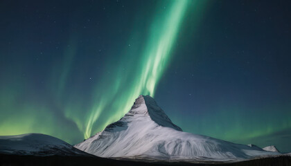 Northern Lights dance above a snow-covered mountain peak under a dark blue night sky.