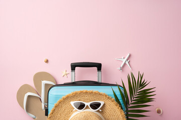 Travel essentials arranged on a pastel pink background creating a summer vibe. Vacation preparation...