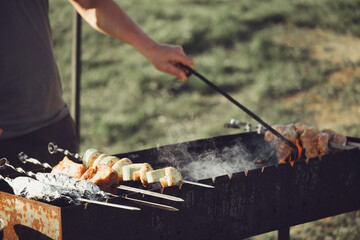 Cooking Shish Kebab Skewers Over Hot Coals on a Grill Outdoors