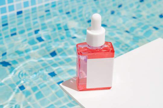 Skincare serum by the pool on a sunny summer day