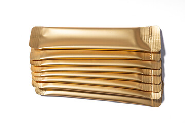Gold collagen jelly sachets on white backdrop