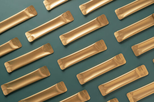 Gold jelly collagen sachets on green background