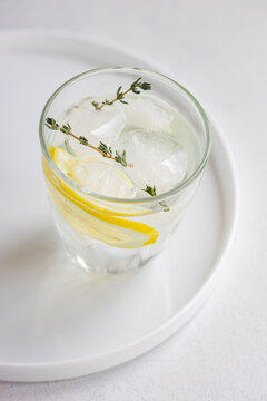 Refreshing gin cocktail with lemon and thyme garnish