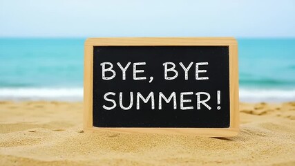 A farewell message bids goodbye to summer on a sandy beach with a calming turquoise sea backdrop