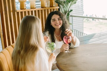Two young women enjoying refreshing drinks at a cafe