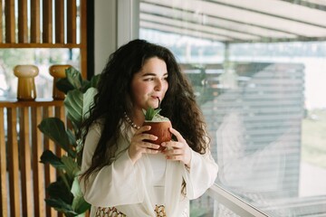 Young woman enjoying a refreshing coconut drink at a cafe