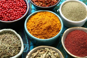 Different aromatic spices on blue tablecloth, closeup