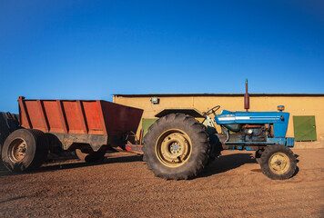  An agricultural tractor without cab in parking lot in hot country.