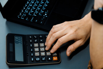 Cropped hand businessman calculating financial and accounting annual report showing digit gross...