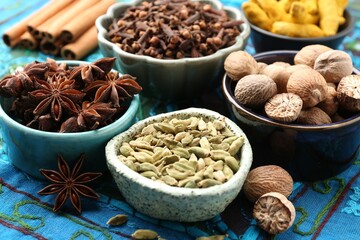 Different aromatic spices on blue tablecloth, closeup