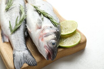 Fresh raw seabass with spices on white table, closeup. Fish and seafood delicacies