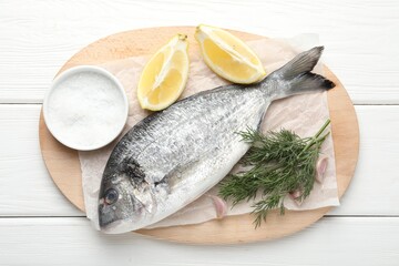 Fresh raw dourade with spices on white wooden table, top view. Fish and seafood delicacies