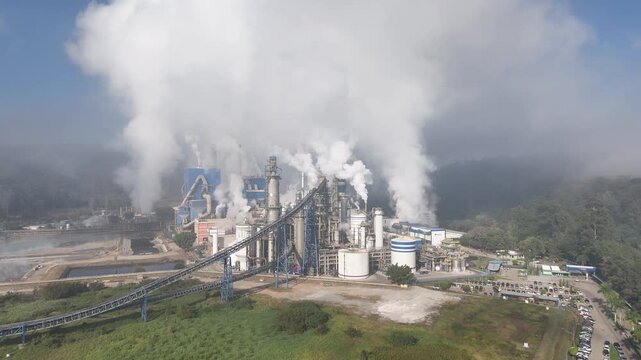 Drone captura ind&uacute;stria de papel e celulose com chamin&eacute;s e caldeiras liberando fuma&ccedil;a, evidenciando polui&ccedil;&atilde;o do ar e os impactos ambientais do setor industrial sobre a natureza.