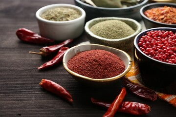 Different aromatic spices on wooden table, closeup