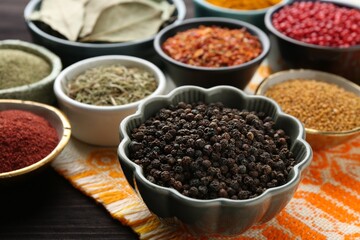 Different aromatic spices on wooden table, closeup