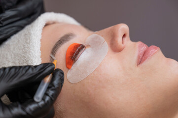 Caucasian woman undergoing eyelash lamination procedure. 