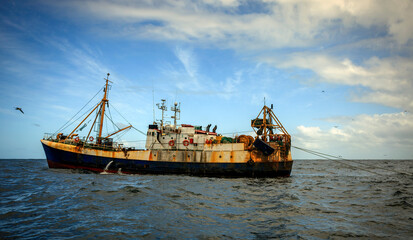 An old fishing trawler is fishing in distant oceanic waters.