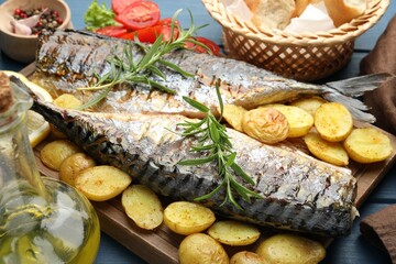 Tasty roasted mackerels served with spices and vegetables on table, closeup. Homemade seafood dish