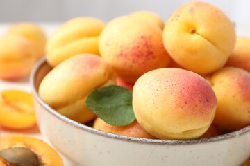 Fresh ripe apricots in bowl on table, closeup