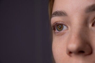 Close-up portrait of a woman after eyelash lamination procedure. 