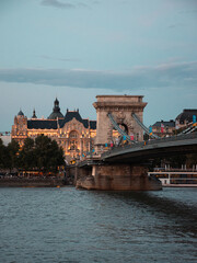 Naklejka premium View of the Chain Bridge and illuminated Gresham Palace at dusk in Budapest, Hungary
